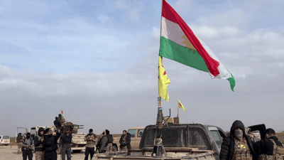 بە ئاڵاى کوردستانەوە لە چاوەڕوانى گەیشتنى هێزەکانى ئاسایشى سووریادا وەستاونلا