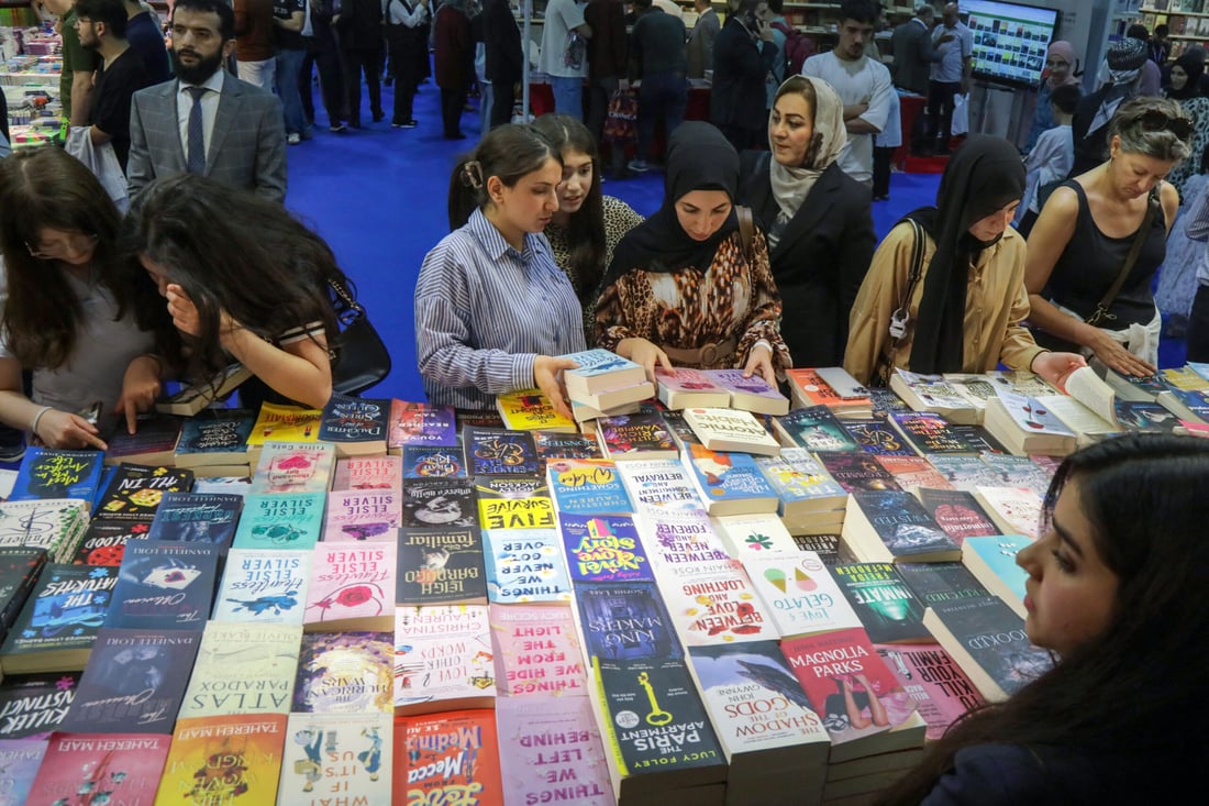 Visitors choose books during the 17th Arbil International Book Fair, in the capital of the autonomous Kurdish region of northern Iraq, on April 9, 2025. (Photo by Safin HAMID / AFP)