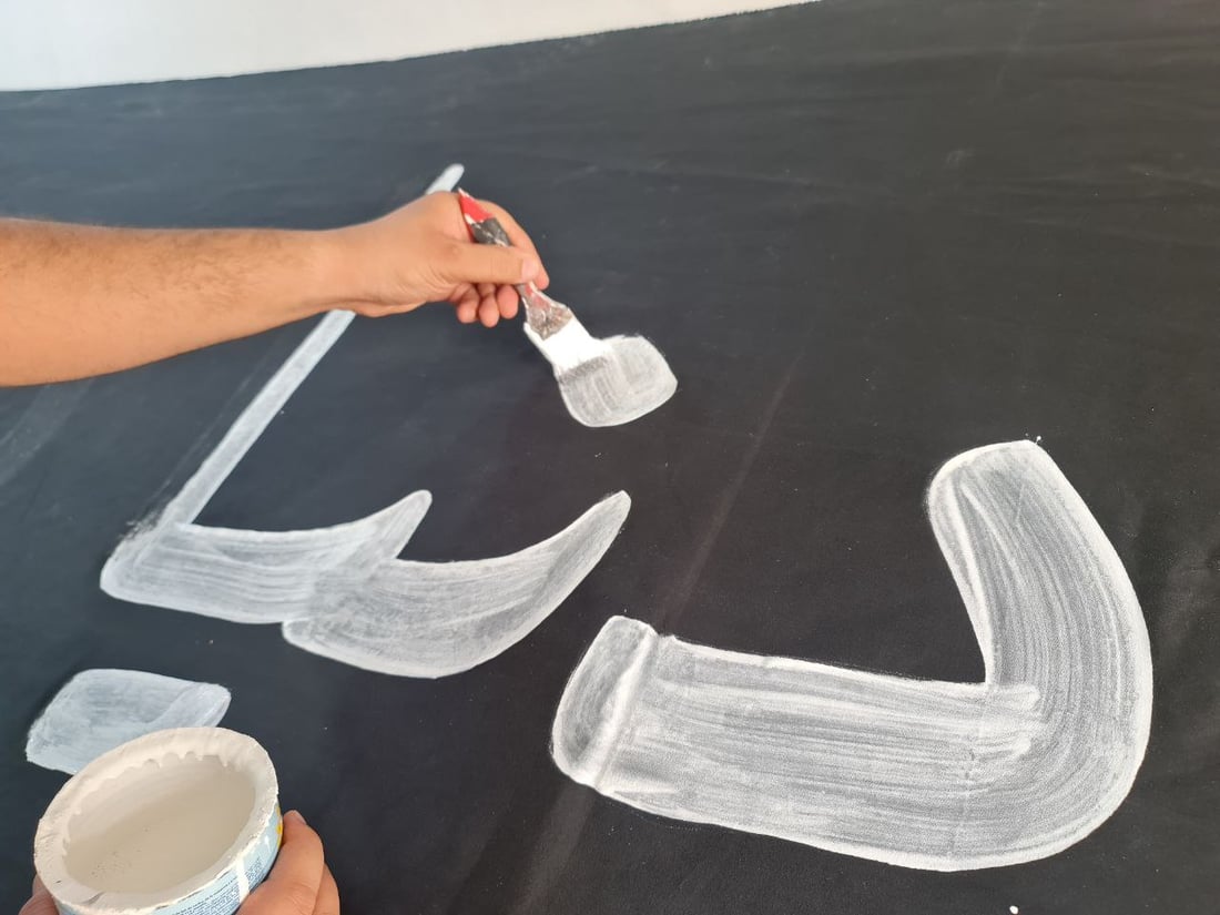 أصباغ أردنية تخط رايات الحسين في السماوة.. صور مع خطاطي شارع الجسر