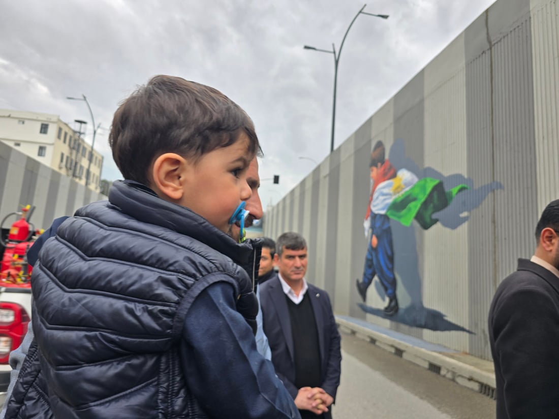 وێنەکەى نەخشێندرا؛ ئەو منداڵەى بە مەمکەمژەیەکەوە بووە سیمبوولى خۆپیشاندانەکان