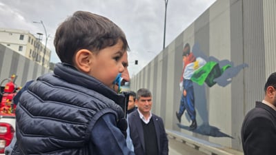 وێنەکەى نەخشێندرا؛ ئەو منداڵەى بە مەمکەمژەیەکەوە بووە سیمبوولى خۆپیشاندانەکان