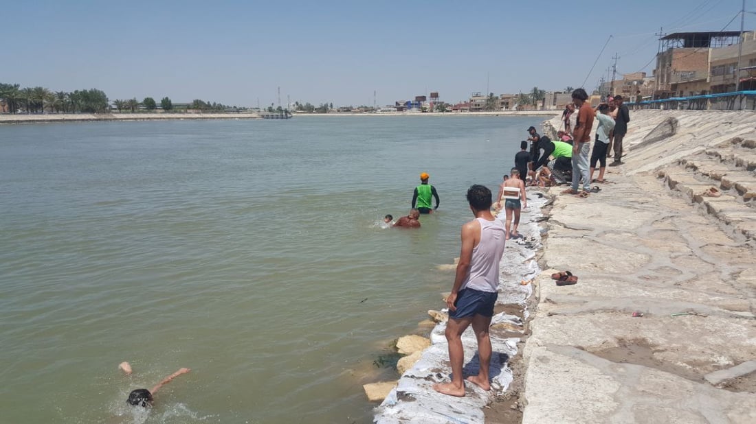 على شط المسيب ومع برودة الفرات.. سباح دولي يدرب الأطفال (صور)