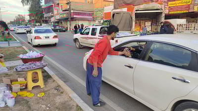 چەند گەنجێکی خۆبەخش بەر لە بانگی مەغریب ئاو و خواردن دەدەنە شۆفیران