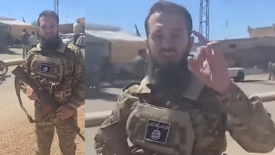 سەربازێکی سوریا بە لۆگۆی داعشەوە لە دەروازەی سوەیدایە