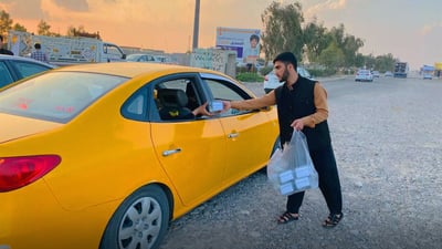کۆمەڵێک گەنجی خۆبەخش لە رێگای کەرکوک بۆ بەغدا خواردن و ئاو دەدەن بە رێبواران